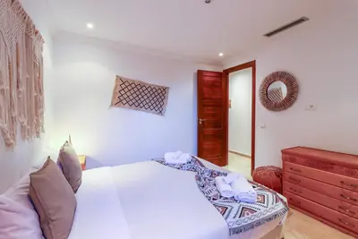 a bedroom with a white bed and a red dresser at La Kasbah - 2bdr- Parking - Wifi - Terrasse in Marrakech