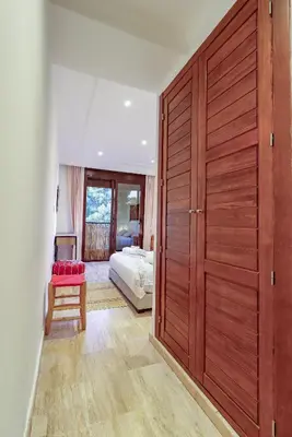 a bedroom with a large wooden door and a bed at La Kasbah - 2bdr- Parking - Wifi - Terrasse in Marrakech