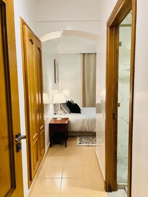 a bedroom with a bed and a desk and a door at Appartement Centre de Gueliz in Marrakech