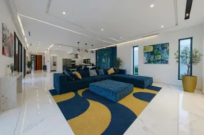 a living room with a blue couch and a yellow and blue rug at Villa AZUR - Wifi, Piscine chauffée, Sans vis-à-vis in Marrakech