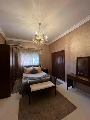 a bedroom with a bed and a chandelier at Appartement familiale et traditionnel in Marrakech