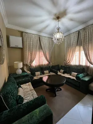 a living room with green furniture and a chandelier at Appartement familiale et traditionnel in Marrakech