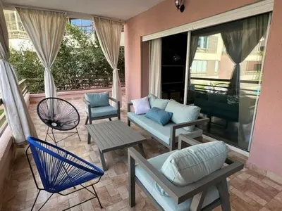a living room with a couch and chairs on a patio at Appartement familial in Marrakech