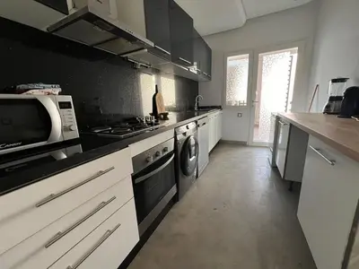 a kitchen with a microwave and a stove top oven at Appartement familial in Marrakech