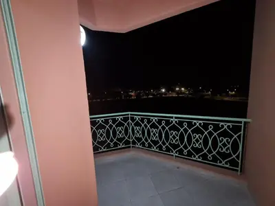 a balcony with a view of the city at night at résidence ATLASS in Marrakech