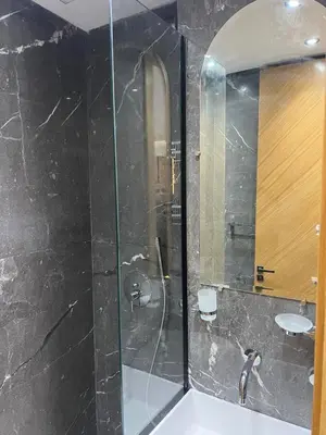 a bathroom with a glass shower and a sink at elite garden appartment in Marrakech