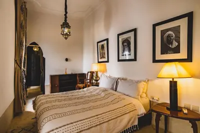 a bedroom with a bed and pictures on the wall at Riad El Ayadi, Moorish villa in Marrakech