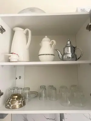 a shelf filled with glass dishes and pitchers at Medina Marrakech Life in Marrakech