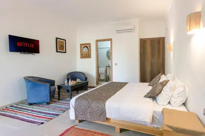 a bedroom with a king sized bed and a desk at Abraj Bladi Resort in Marrakech