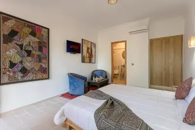 a bedroom with a large bed and a quilt on the wall at Abraj Bladi Resort in Marrakech