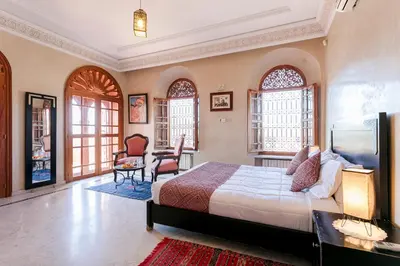a bedroom with a bed and a desk and chairs at Abraj Bladi Resort in Marrakech