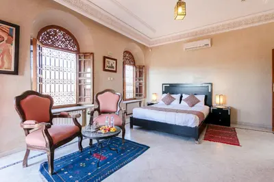 a bedroom with a bed and a table and chairs at Abraj Bladi Resort in Marrakech