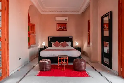 a bedroom with a bed and a red rug at Abraj Bladi Resort in Marrakech