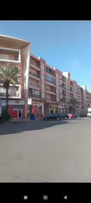 a street with cars parked in front of a building at Studio lumineux pour location journalière in Marrakech