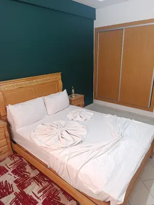 a bedroom with a large bed with white sheets at Studio lumineux pour location journalière in Marrakech