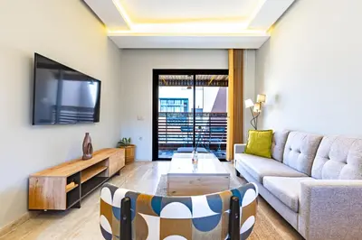 a living room with a couch and a tv at Central Marrakesh Apartment in Marrakech