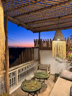 a patio with a couch and tables on a balcony at Riad El Charsa, logement entier 4 à 6 personnes, proche Jemaa El Fna, Rooftop et bassin chauffé in Marrakech