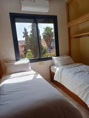 two beds in a room with a window at Villa Caprice Palace in city center in Marrakech