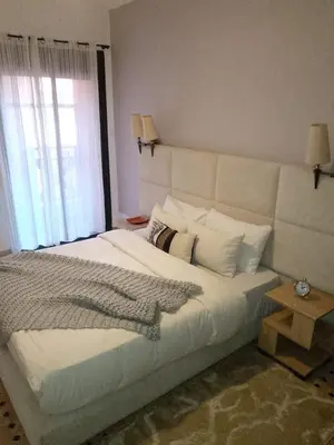 a bedroom with a large white bed with a window at Appartement moderne à 5piscines in Marrakech