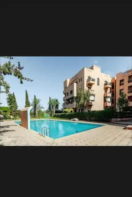 a swimming pool in front of two apartment buildings at Appartement moderne à 5piscines in Marrakech