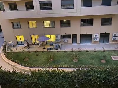 an apartment building with a garden in front of it at Appartement moderne à 5piscines in Marrakech
