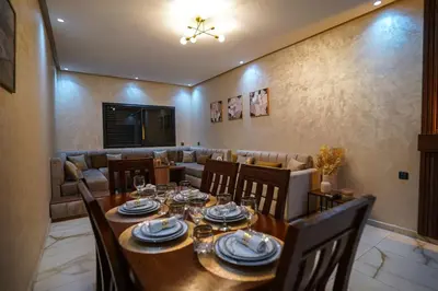 a dining room with a wooden table and chairs at New and luxurious apartment with a pool in Marrakech