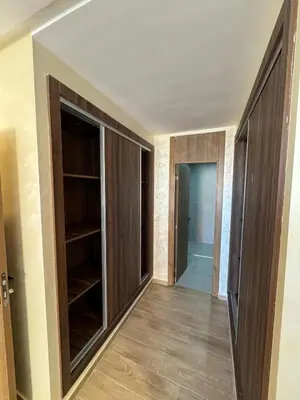 a hallway with wooden doors and shelves in a house at Burj Malak appartement pour les familles in Marrakech