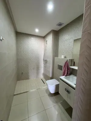 a bathroom with a shower and a toilet and a sink at Burj Malak appartement pour les familles in Marrakech