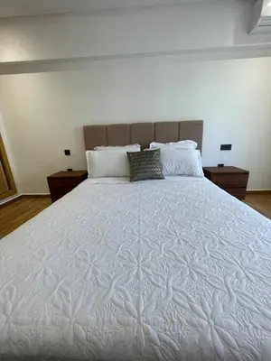 a large white bed in a bedroom with two night stands at Luxury 2BR Pool Apartement Marrakech in Marrakech