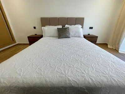 a large white bed in a bedroom with two night stands at Luxury 2BR Pool Apartement Marrakech in Marrakech