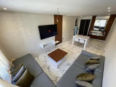 a living room with a couch and a flat screen tv at Luxury 2BR Pool Apartement Marrakech in Marrakech