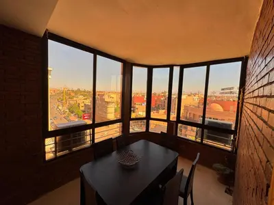 a room with a table and a view of a city at Appartement près de la gare de Marrakech in Marrakech