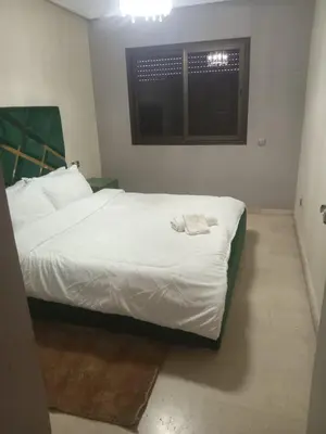 a bedroom with a bed with white sheets and a window at Résidence SOFIA PALMERAIE in Marrakech