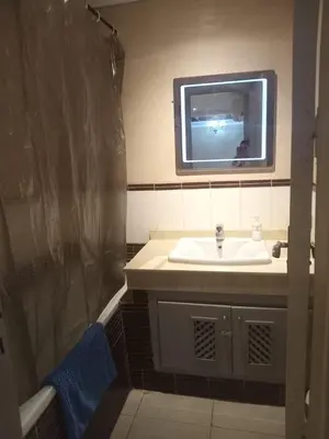 a bathroom with a sink and a tv on the wall at Résidence SOFIA PALMERAIE in Marrakech