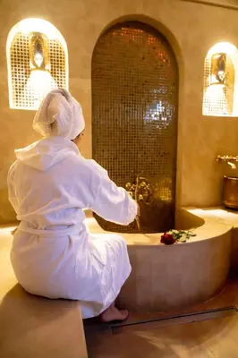a woman sitting on the floor in front of a sink at Riad Dar Yousra in Marrakech