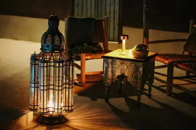 a lamp in a living room with a table and a chair at Hotel & Spa La Ferme El Dar in Marrakech
