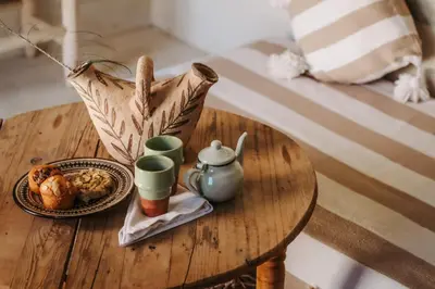 a wooden table with a tea pot and a plate of food at Hotel & Spa La Ferme El Dar in Marrakech