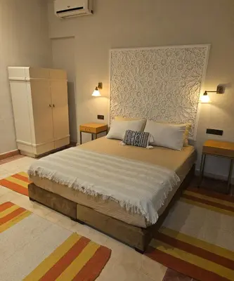 a bedroom with a bed with two pillows on it at Maison de vacances avec piscine in Marrakech