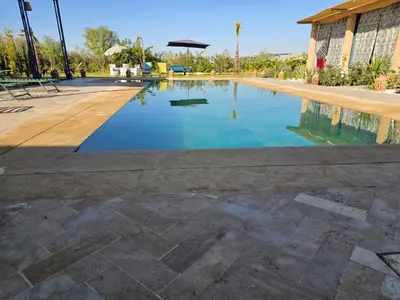 a swimming pool in a resort with blue water at Maison de vacances avec piscine in Marrakech