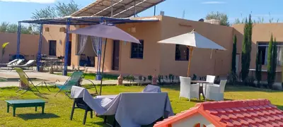 a group of chairs and umbrellas in front of a building at Maison de vacances avec piscine in Marrakech