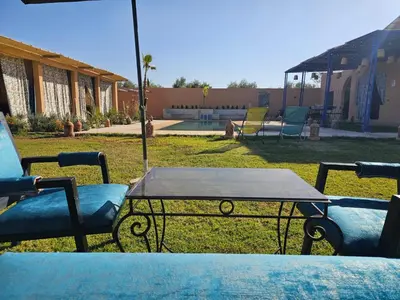 a table and chairs in a yard with a table and chairs at Maison de vacances avec piscine in Marrakech