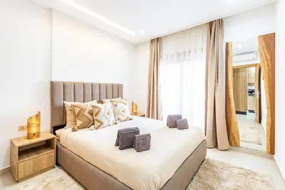 a bedroom with a large bed and a mirror at Le COSY CHIC- NEUF - Modern & Chic - Terrasse et Confort - CLIM PARKING et WIFI Gratuit ! GUELIZ in Marrakech