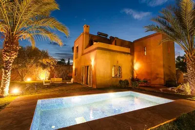 a house with a swimming pool in front of it at Your Traditional Marrakchi Villa in Marrakech