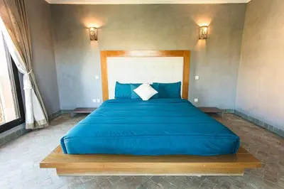 a large blue bed in a bedroom with two lights at Your Traditional Marrakchi Villa in Marrakech