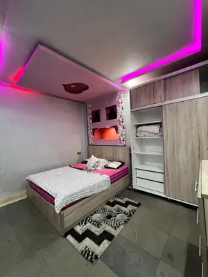 a bedroom with a bed with purple lights on it at Cozy apartment center Gueliz in Marrakech