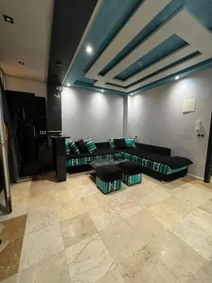 a living room with a couch and two stools at Cozy apartment center Gueliz in Marrakech