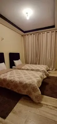 two beds in a bedroom with a large bedskirts at Résidence Hamza - Appartement familial in Marrakech