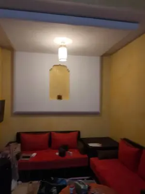 a living room with a red couch and a large screen at Said MM in Marrakech