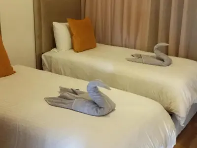 two beds with towel animals on top of them at Domaine de Noria Isli 2 - Magnifique 2 chambres - Vue directe sur la piscine in Marrakech
