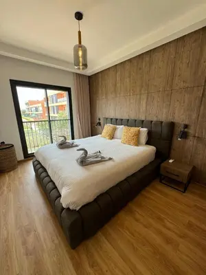 a bedroom with a large bed in a room with a window at Domaine de Noria Isli 2 - Magnifique 2 chambres - Vue directe sur la piscine in Marrakech